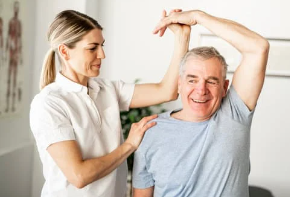 Image of a senior receiving physiotherapy treatment for shoulder pain in a Physiotherapy clinic in Waterloo. The senior is seated or lying down, with a physiotherapist examining or treating the shoulder. Medical equipment and a physiotherapy clinic setting may be visible in the background. The senior may be wearing loose clothing to allow for easy movement during the treatment.