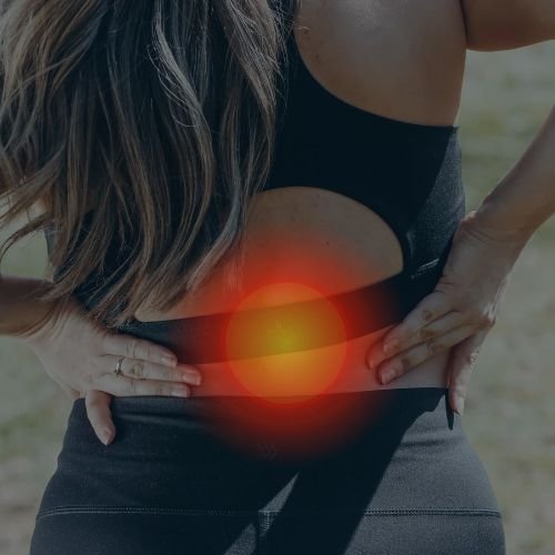 Woman is having back pain and we at restore life physiotherapy and wellness waterloo can treat the Back pain